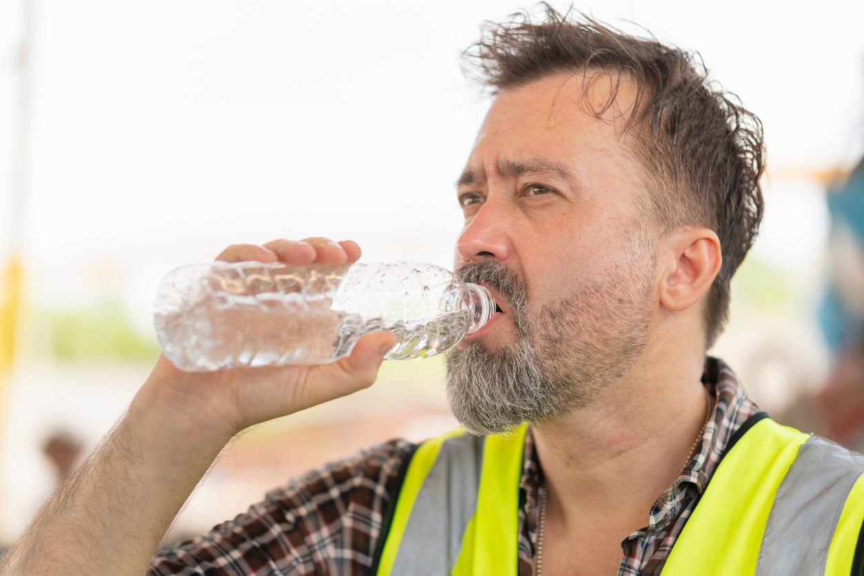 Caucasian engineer man drinking water at the precast factory site, Worker man drinking water at construction site